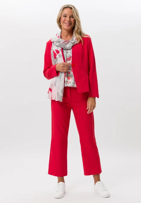 Dame mit roter Jacke und Hose und bemusterten Schal und T-Shirt