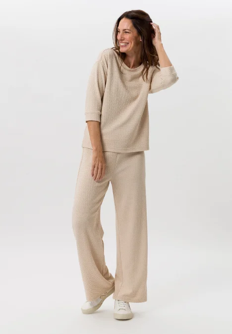 Dame mit beigem Shirt und beiger Hose