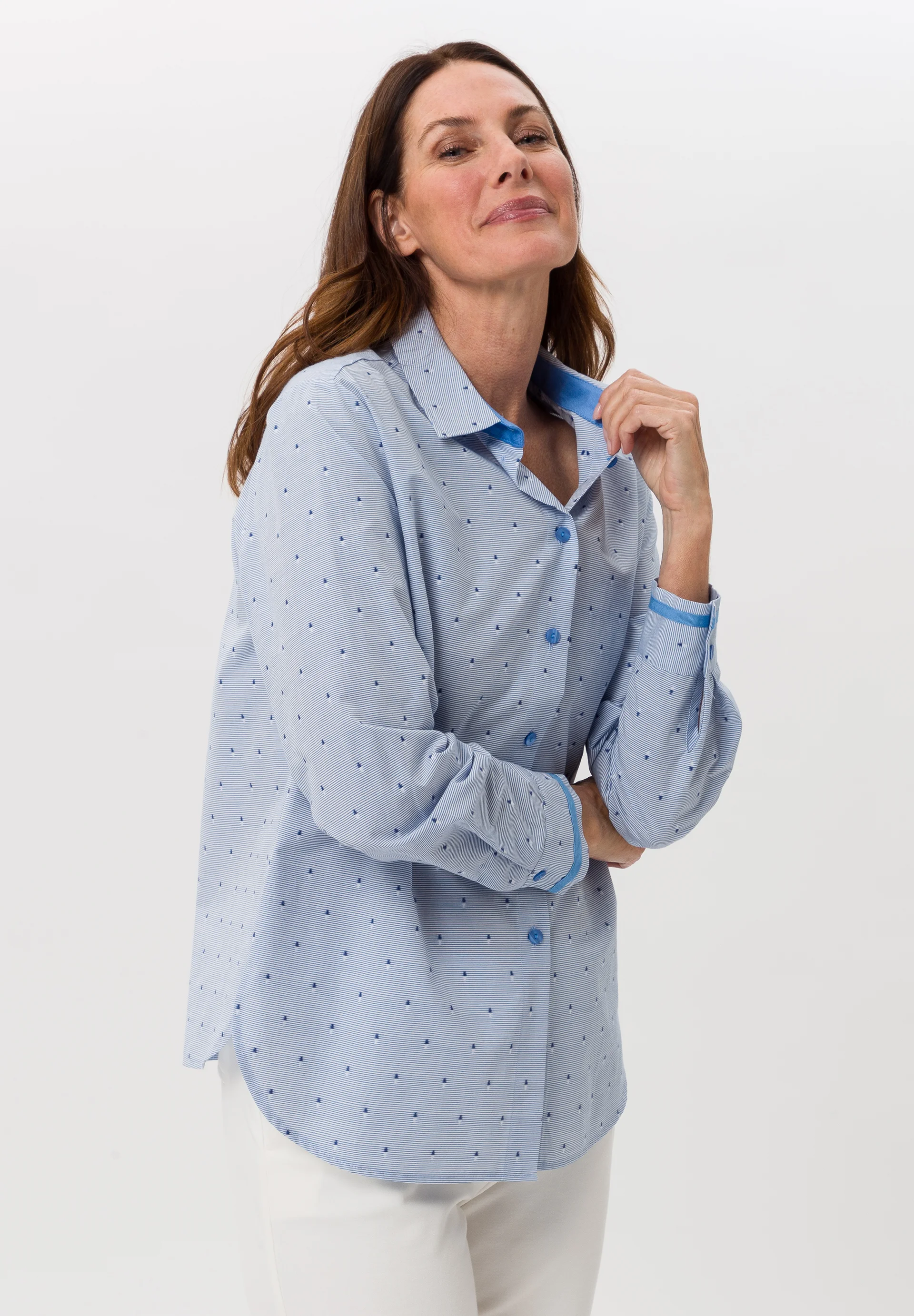 Bild einer Dame mit blauen Hemd und weißer Hose
