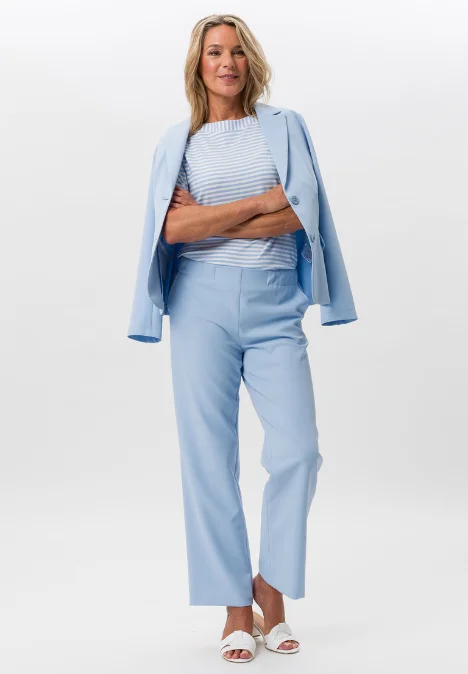 Dame mit Hellblauer Jacke, Hose und bemusterten Shirt