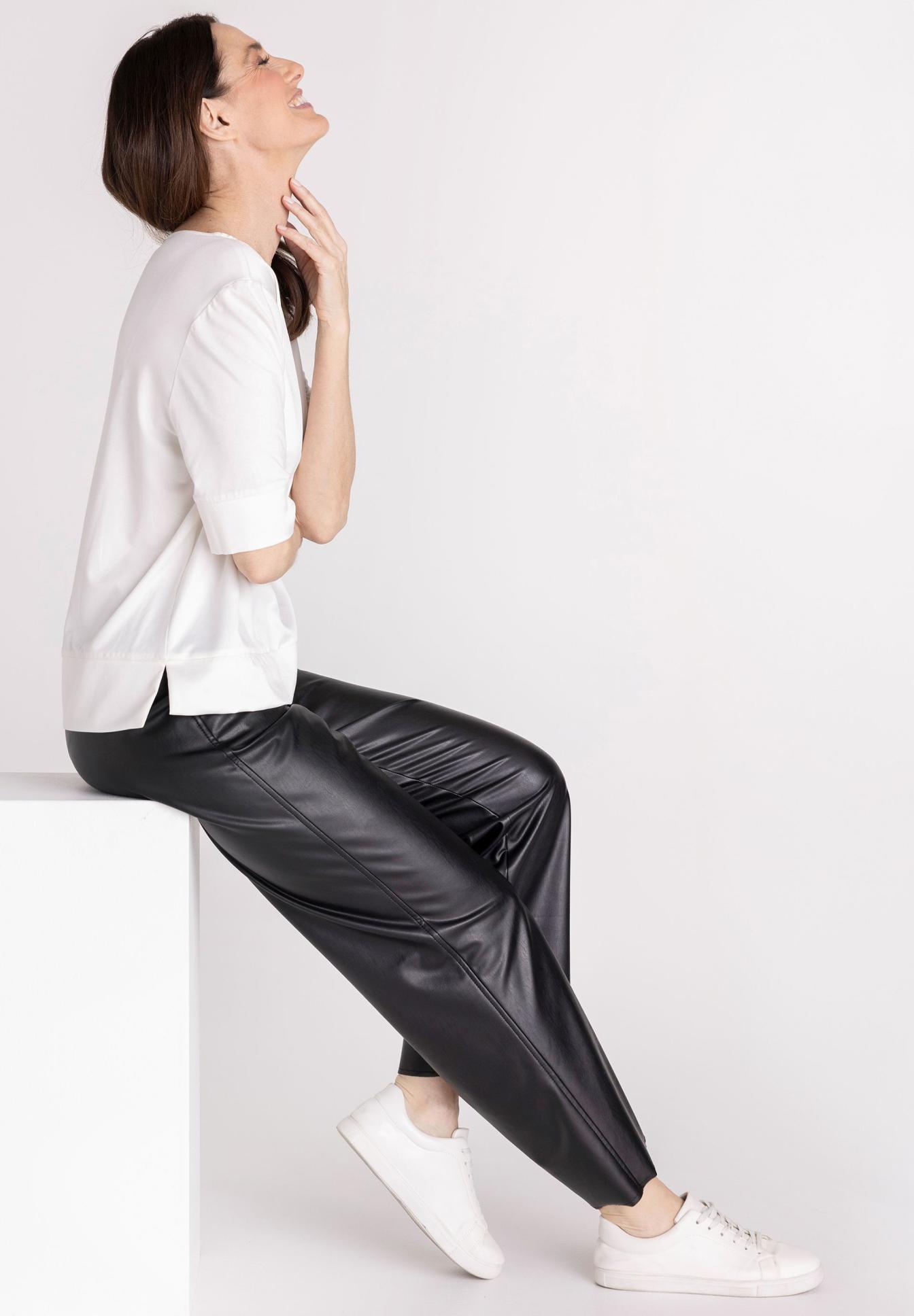 weißes Oberteil, schwarze Lederhose, Lederhose, sportliche Sneaker, Casual Outfit